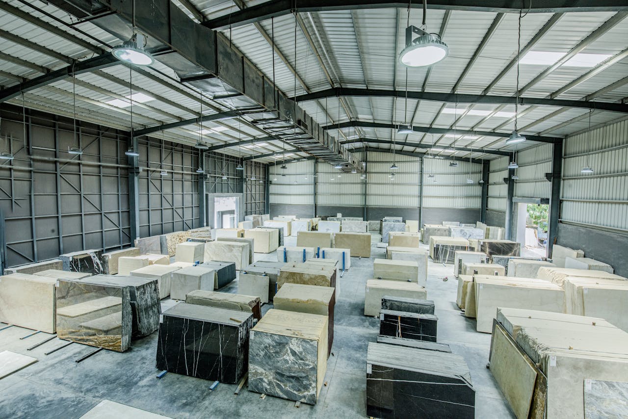 gallery-1 Expansive warehouse filled with large stone slabs for industrial use.